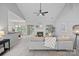 Cozy living room featuring fireplace with white mantel, ceiling fan, and large windows for natural light at 9118 Pine Springs Ct, Huntersville, NC 28078