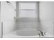 This large soaking tub in the primary bathroom has marble tile surround and chrome fixtures at 10161 Castlebrooke Dr, Concord, NC 28027