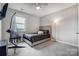 Neutral bedroom with a comfortable bed, modern hanging chair, and a ceiling fan at 10161 Castlebrooke Dr, Concord, NC 28027