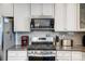 This modern kitchen features white cabinets, stainless steel appliances and granite countertops at 10161 Castlebrooke Dr, Concord, NC 28027