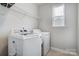 Bright laundry room features a large washer and dryer, convenient shelving, and a window at 10161 Castlebrooke Dr, Concord, NC 28027