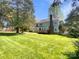 Spacious backyard view with a deck, lush green grass, and mature trees offering shade and privacy at 1090 Briarcliff Rd, Mooresville, NC 28115