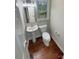 Cozy half bathroom featuring a pedestal sink, modern toilet, and hardwood flooring at 1090 Briarcliff Rd, Mooresville, NC 28115