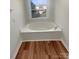 Bathroom featuring a luxurious, tiled-in bathtub perfect for relaxation and a window providing natural light at 1090 Briarcliff Rd, Mooresville, NC 28115