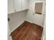 Functional laundry room with white cabinets, hardwood floors, and an exterior door at 1090 Briarcliff Rd, Mooresville, NC 28115