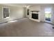Living room featuring a painted brick fireplace, neutral walls, carpet flooring, and exterior access at 1090 Briarcliff Rd, Mooresville, NC 28115