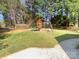 Backyard features a wooden play set with a slide, swings, and a climbing area for entertainment at 1090 Briarcliff Rd, Mooresville, NC 28115