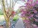 Lush backyard with a stone walkway and colorful landscaping, featuring a variety of trees and shrubs at 11 Tallassee St, Badin, NC 28009