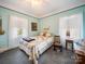 Comfortable bedroom with soft blue walls, vintage furniture, and natural lighting at 11 Tallassee St, Badin, NC 28009