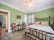 Cozy bedroom with green walls, decorative furniture, and a comfortable wrought iron bed frame at 11 Tallassee St, Badin, NC 28009