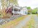 Charming white home with a welcoming porch, sunroom, rockscaping and well-maintained yard at 11 Tallassee St, Badin, NC 28009