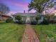 Charming single-story home featuring a brick walkway and inviting front porch at 11 Tallassee St, Badin, NC 28009