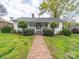 Charming single-story home featuring a brick walkway and inviting front porch at 11 Tallassee St, Badin, NC 28009