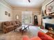 Bright living room featuring a brick fireplace, access to the front porch, and neutral carpet at 11 Tallassee St, Badin, NC 28009