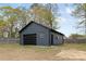 Detached blue garage/workshop with a roll up door, offering extra storage at 121 Tanglewood Dr, Kannapolis, NC 28081