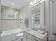 Bathroom featuring shower-tub combo with decorative tile, a vanity with granite countertops, and ample lighting at 138 Great Point Dr, Mooresville, NC 28117