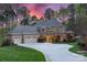 Stately home featuring a circular driveway, three car garage and manicured lawn in lush surroundings at 138 Great Point Dr, Mooresville, NC 28117
