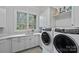 Spacious laundry room boasts modern washer and dryer, ample counter space, and natural light at 138 Great Point Dr, Mooresville, NC 28117
