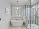 Bright bathroom features a soaking tub, glass shower, and a window with plantation shutters at 138 Great Point Dr, Mooresville, NC 28117