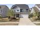 Charming two-story home featuring stone accents, a two-car garage, manicured lawn, and covered porch entry at 15126 Shallow Ridge Rd, Charlotte, NC 28278