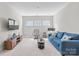 An ample living room with neutral walls and carpet, a blue couch, a media center, and natural light at 15126 Shallow Ridge Rd, Charlotte, NC 28278