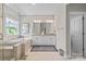 A luxurious bathroom featuring a soaking tub, a glass enclosed shower, and vanity with double sinks at 15126 Shallow Ridge Rd, Charlotte, NC 28278