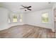 A large bedroom features a ceiling fan, windows and wood flooring at 157 Fraley Rd, Gastonia, NC 28052