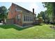 Spacious backyard featuring a well-maintained lawn, a deck, and a charming sunroom addition to the brick home at 15964 Cumnor Ln, Charlotte, NC 28277