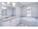 Bright bathroom with a soaking tub, granite vanity, and updated fixtures, combining comfort and style at 15964 Cumnor Ln, Charlotte, NC 28277