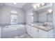 Bathroom with white cabinets, granite countertops, and a soaking tub, offering a blend of luxury and functionality at 15964 Cumnor Ln, Charlotte, NC 28277