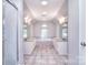 Well-lit bathroom with dual vanities, a soaking tub, and tile flooring, creating a spa-like experience at 15964 Cumnor Ln, Charlotte, NC 28277