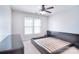 Modern bedroom featuring a ceiling fan, a black bed frame, and two bright windows at 15964 Cumnor Ln, Charlotte, NC 28277