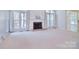 Bright living room featuring a fireplace, large windows, and carpet flooring at 15964 Cumnor Ln, Charlotte, NC 28277