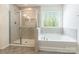 Bathroom featuring a tub, window, and glass-enclosed shower at 162 Aspire Cir, Wingate, NC 28174
