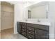 Bathroom featuring a large double vanity with dark cabinets and a walk-in closet at 162 Aspire Cir, Wingate, NC 28174