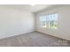 Bright bedroom with neutral carpet and a view of the neighborhood through the windows at 162 Aspire Cir, Wingate, NC 28174