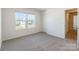 Well-lit bedroom featuring neutral carpet and an adjacent doorway at 162 Aspire Cir, Wingate, NC 28174