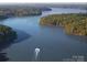 Breathtaking aerial view of a lake surrounded by lush, green forests with a boat sailing through it at 19650 Harbor Watch Ct, Lancaster, SC 29720