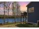 Beautiful lakeside backyard with a deck, fire pit, and mature trees, perfect for outdoor entertaining and relaxation at 19650 Harbor Watch Ct, Lancaster, SC 29720
