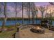 Charming outdoor fire pit area with stone accents, offering a relaxing space to enjoy the lake view and tranquil surroundings at 19650 Harbor Watch Ct, Lancaster, SC 29720