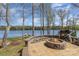 Outdoor fire pit area with brick seating and lake views, creating a cozy and inviting space for relaxation and entertaining at 19650 Harbor Watch Ct, Lancaster, SC 29720