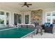 Covered outdoor living area with a stone fireplace and comfortable seating is ideal for entertaining at 19650 Harbor Watch Ct, Lancaster, SC 29720