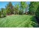 Expansive backyard with a lush lawn, mature trees and manicured landscape at 202 Weeping Spring Dr, Mooresville, NC 28115