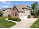 Side exterior of home with attached garage and well maintained lawn and landscaping at 202 Weeping Spring Dr, Mooresville, NC 28115