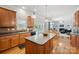 Well-lit kitchen with wood cabinets, a center island, and a seamless connection to the dining and living areas at 202 Weeping Spring Dr, Mooresville, NC 28115