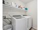 Functional laundry room featuring a washer, dryer, and storage shelf for laundry supplies at 202 Weeping Spring Dr, Mooresville, NC 28115