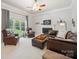 Inviting living room with a fireplace, comfortable leather seating, and a large window at 202 Weeping Spring Dr, Mooresville, NC 28115