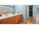 Dual sink vanity with ample cabinet space and view into the closet in the primary bathroom at 202 Weeping Spring Dr, Mooresville, NC 28115