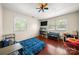 Bright bedroom featuring wood floors, with two windows providing ample natural light and a colorful ceiling fan at 2115 Fowler Secrest Rd, Monroe, NC 28110
