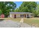 Charming home features a covered porch with swing, red doors, lush lawn and detached storage shed at 2115 Fowler Secrest Rd, Monroe, NC 28110